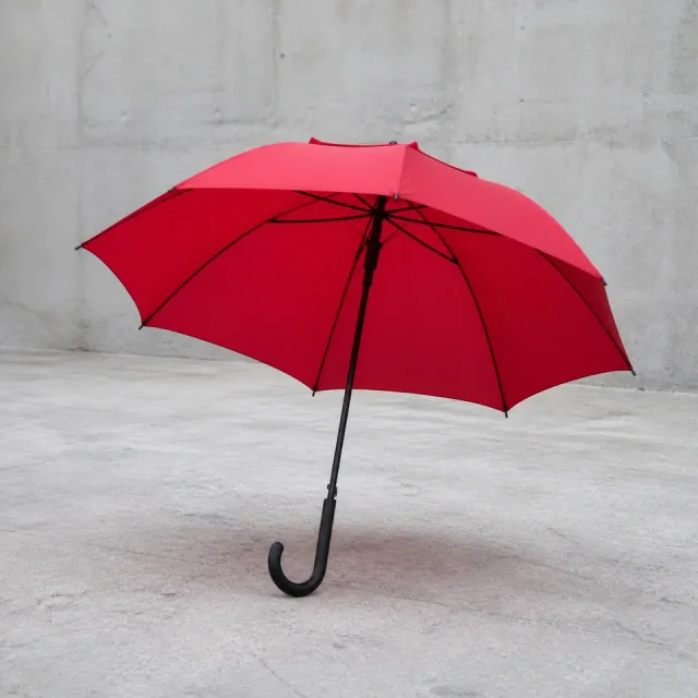 A single red umbrella clearly separated from an uncluttered courtyard